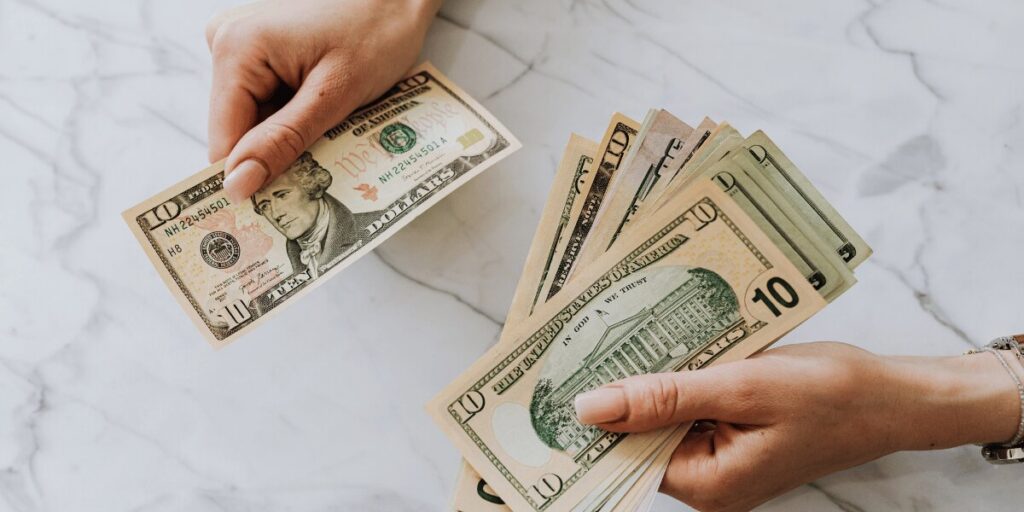 person computing dollar bills